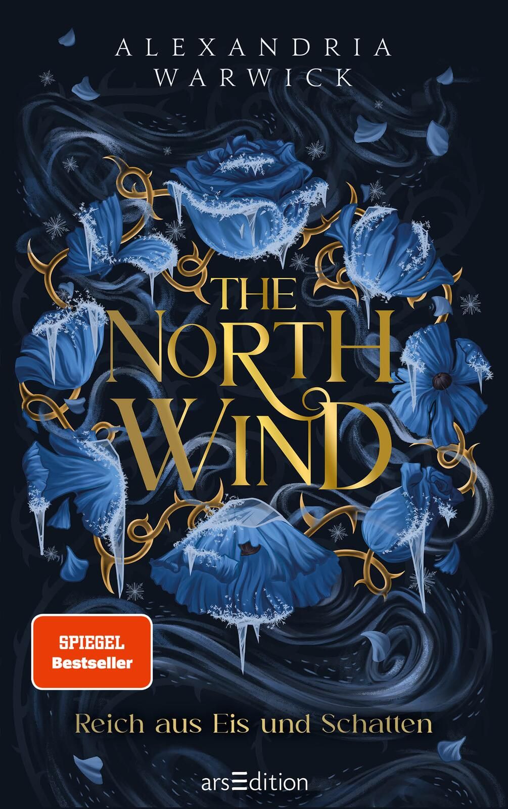 Das Buchcover zeigt eine mystische, dunkelblaue Hintergrundgestaltung, die mit kunstvoll gezeichneten, eisblauen Rosen und verwobenen, grafischen Elementen verziert ist. In der Mitte prangt der Titel „THE NORTH WIND“ in eleganter, goldener Schrift, währen