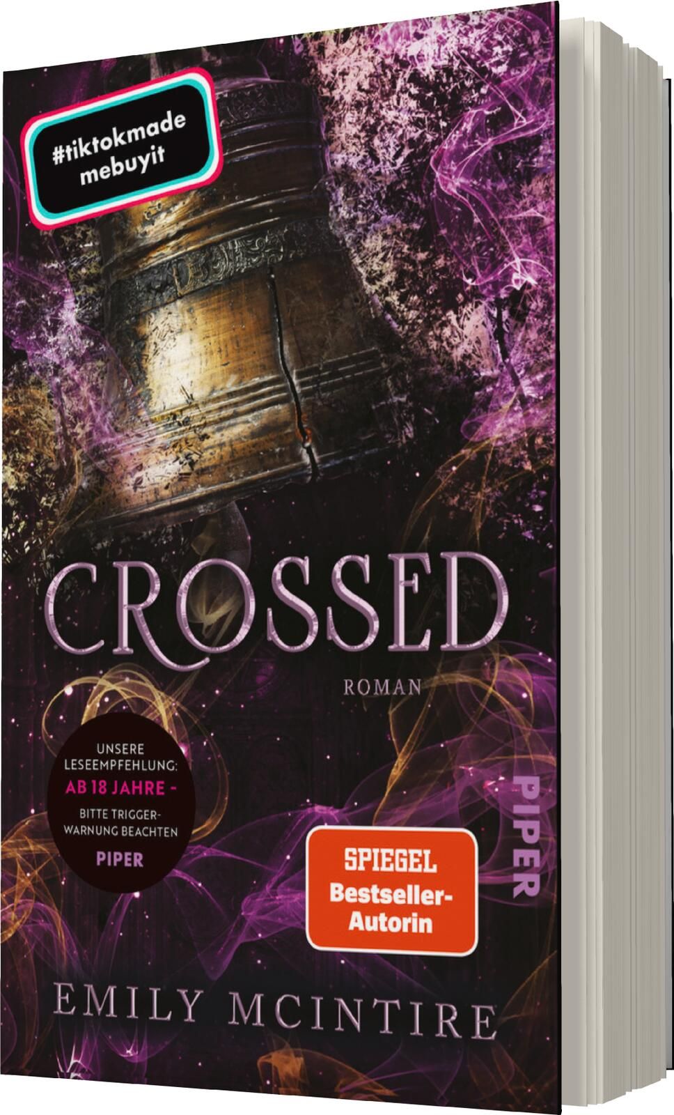 Das Buchcover zeigt einen mysteriösen Hintergrund in lila und schwarzen Farbtönen, der eine spannende Atmosphäre schafft. Im Vordergrund befindet sich ein detailliertes, antikes Artefakt, das von Licht- und Schatteneffekten umgeben ist. Der Titel „CROSSED